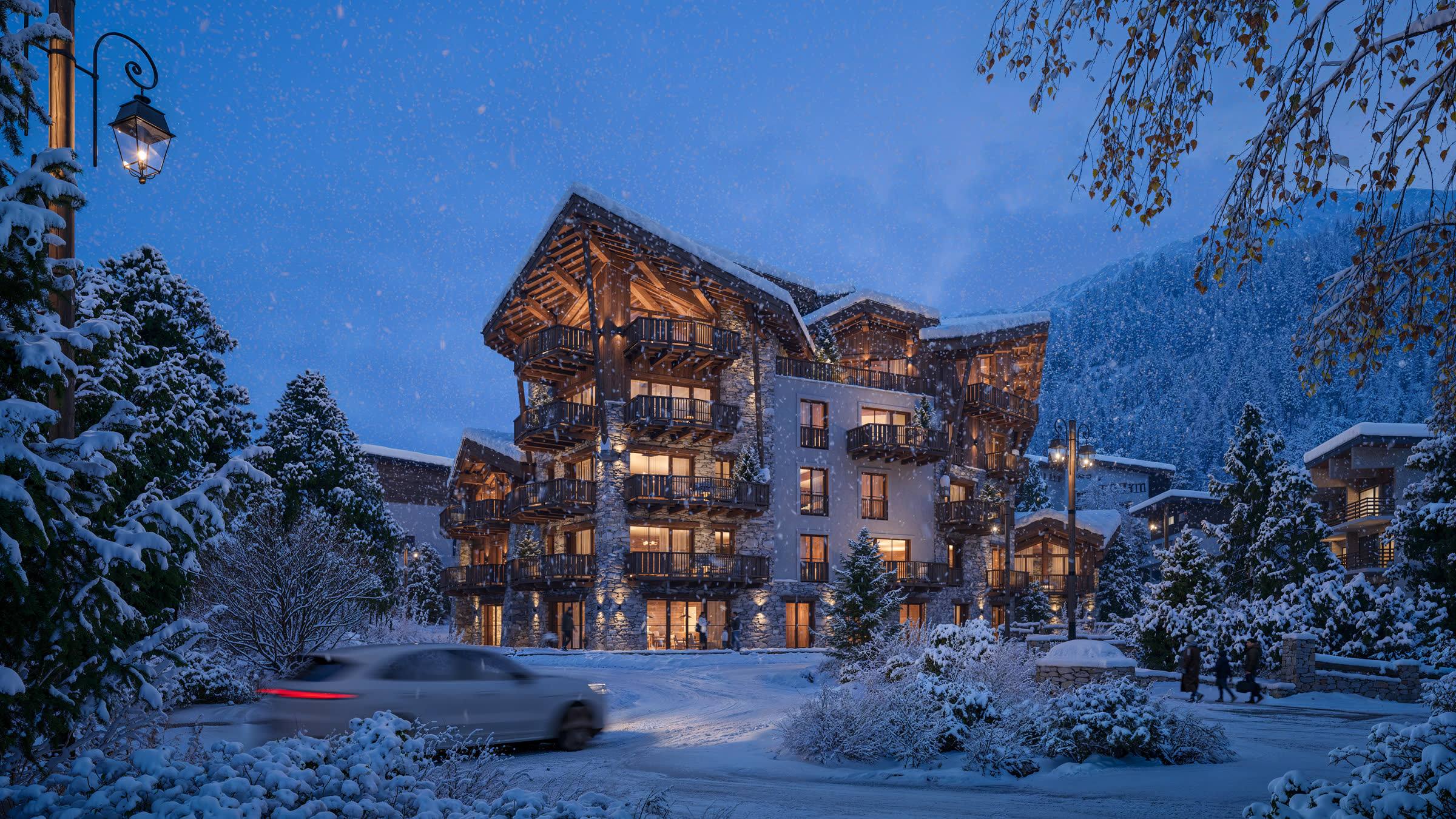 The same facade at nightfall, windows lit above the snow